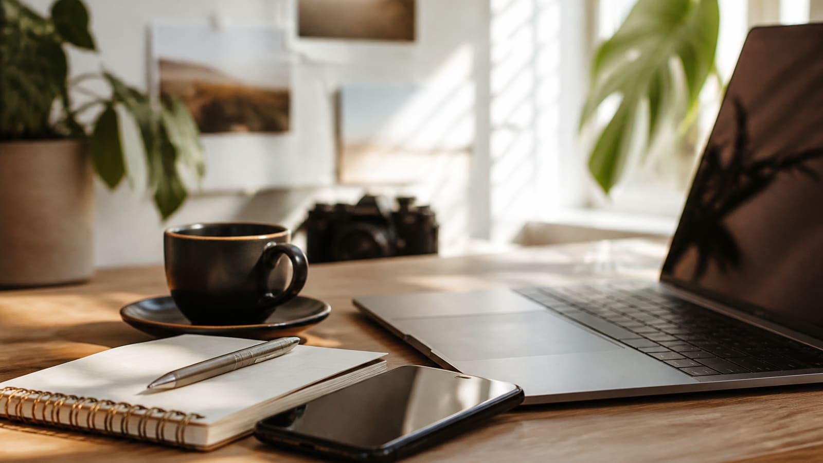 Creator workspace with laptop, phone, and notebook